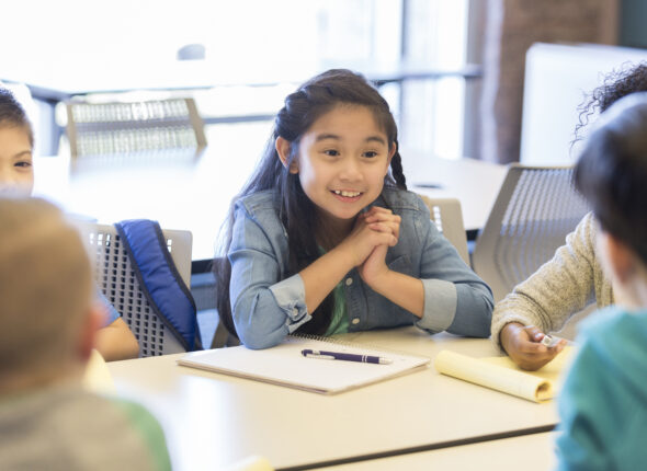 Engaged young student actively participating in a group discussion during a classroom activity, reflecting inclusive and collaborative learning promoted by Bridging Talents